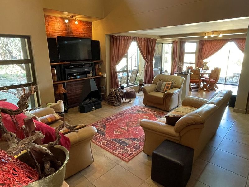 Spacious open-plan living and dining area featuring tiled floors, a built-in fireplace with brick detailing, and large sliding doors leading to the outdoors.
