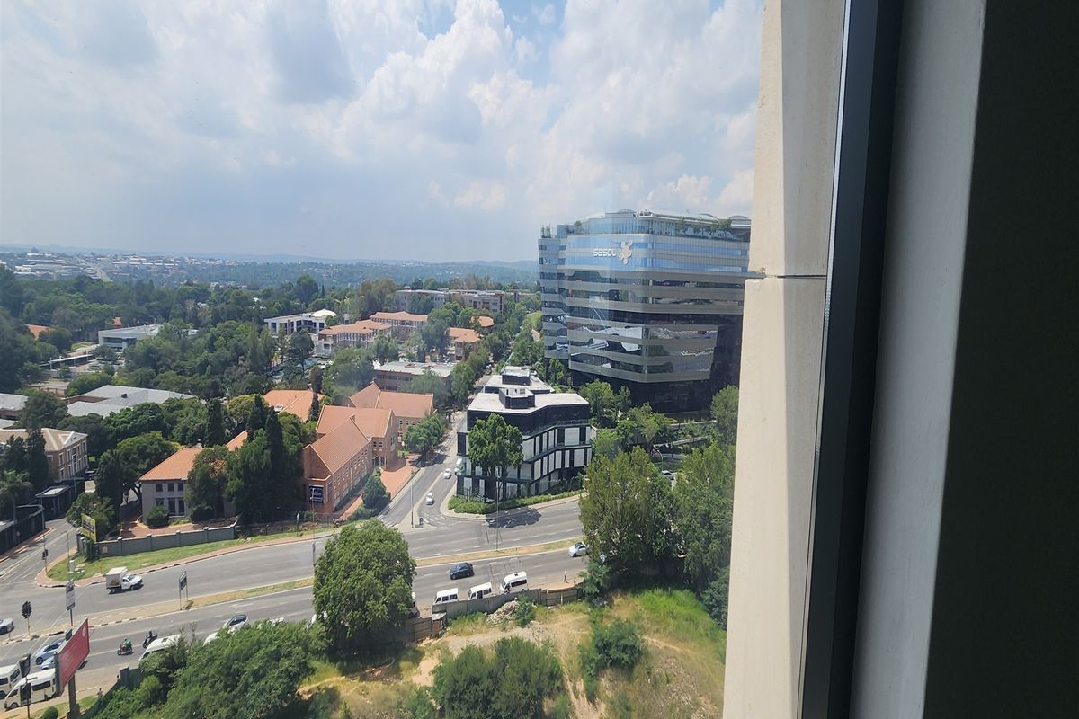 An elevated urban view looking out from an office window over the surrounding neighbourhood and commercial buildings.