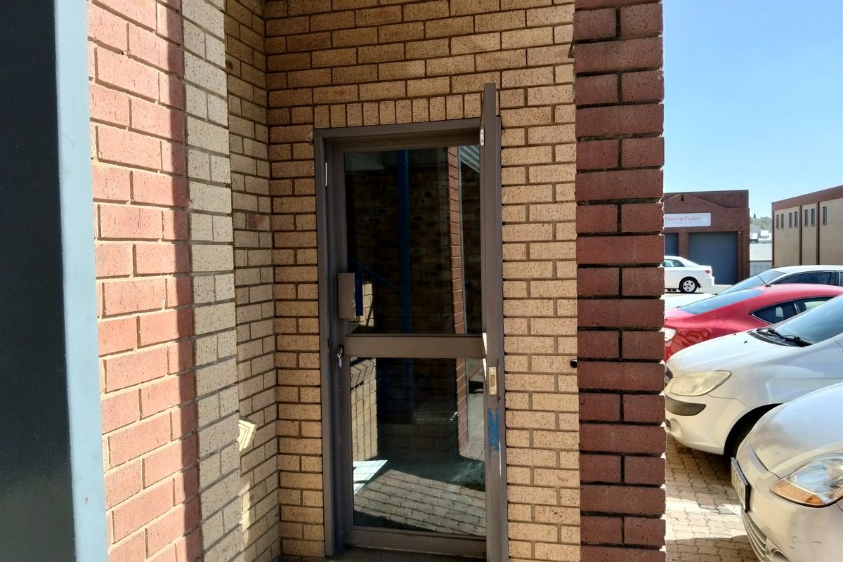 Exterior entrance featuring a brick facade and an aluminium framed glass door providing access to the industrial property.