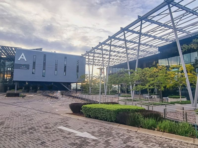 Modern office complex featuring contemporary architectural design with extensive glass facades, steel structural elements, and well-maintained paved exterior grounds.