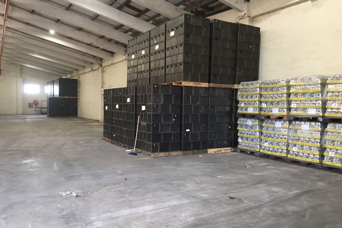 Spacious industrial warehouse unit featuring high ceilings with exposed steel trusses, concrete flooring, and ample storage capacity for logistics or manufacturing operations.