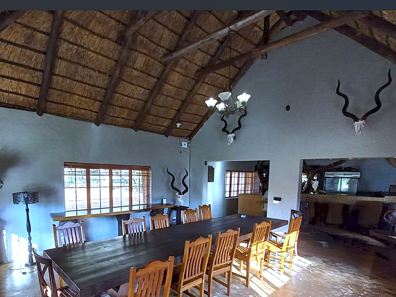 Spacious dining area featuring a high vaulted thatched roof with exposed timber rafters and an adjoining built-in bar area.