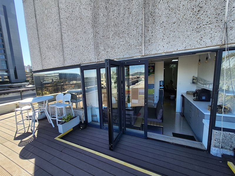 Outdoor balcony area featuring composite decking, bi-fold glass doors, and a small built-in kitchenette, providing a functional transition between indoor and outdoor office space.
