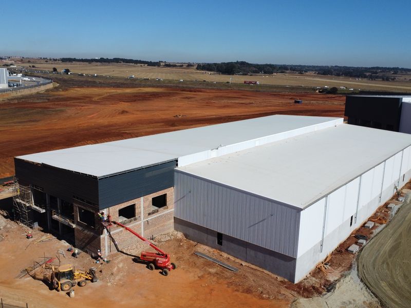 Aerial view of an industrial warehouse property currently under construction, featuring large-span steel roofing and metal cladding on a cleared site.
