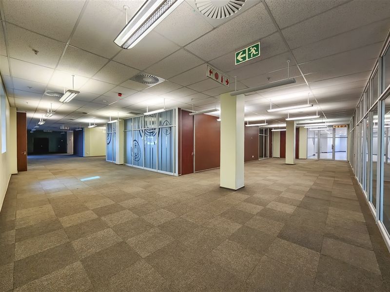 Spacious open-plan office area featuring suspended ceilings, carpet tiles, and glass partitioning, providing a versatile and well-lit professional workspace.