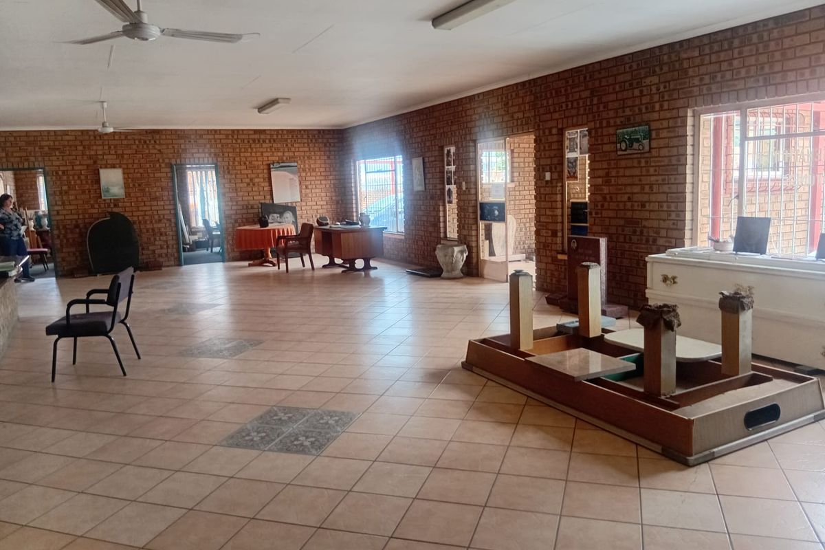 Spacious open-plan industrial area featuring exposed brick walls, ceramic tile flooring, and functional ceiling lighting, suitable for various commercial or office applications.