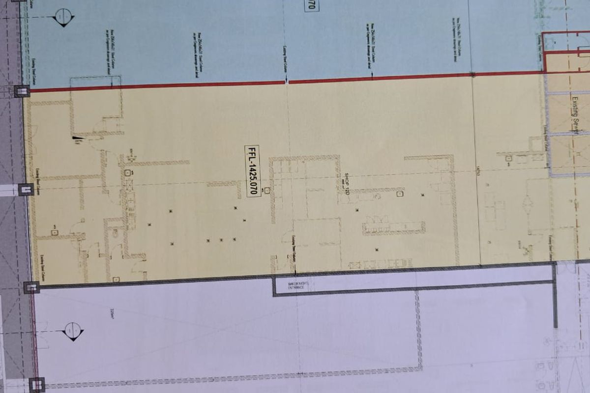 Architectural floor plan detailing the layout of the retail space, including structural columns, ramp access, and designated shop areas.