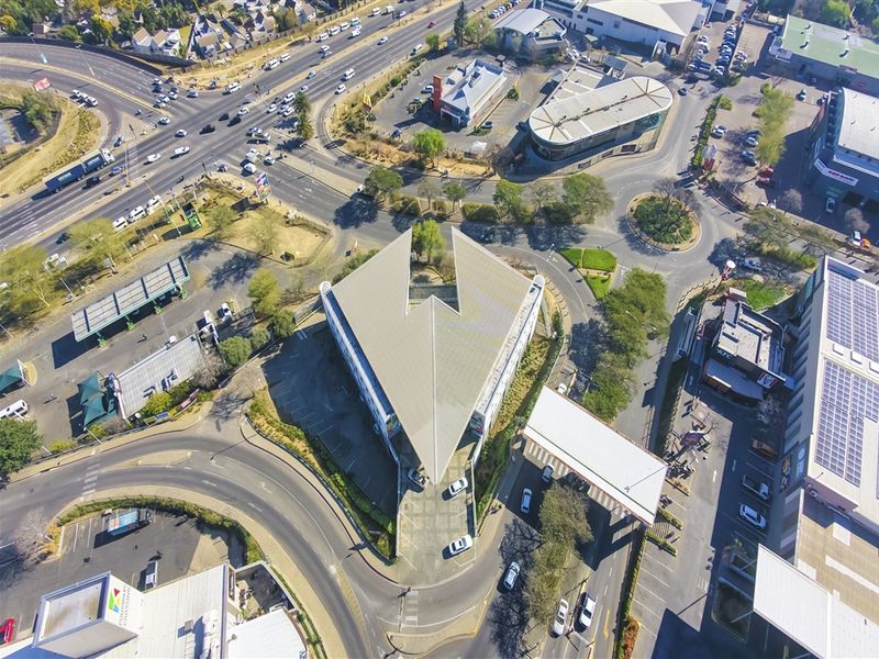 Aerial view of the office property showing its unique triangular building footprint, surrounding parking facilities, and access roads within a commercial precinct.