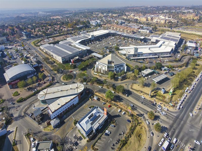 Aerial view of a large commercial office and retail complex featuring extensive parking facilities and surrounding road infrastructure.