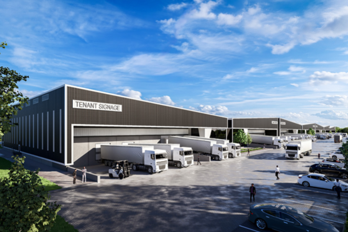 A modern industrial warehouse facility featuring multiple loading docks, expansive paved yard space, and dedicated parking areas for logistics operations.
