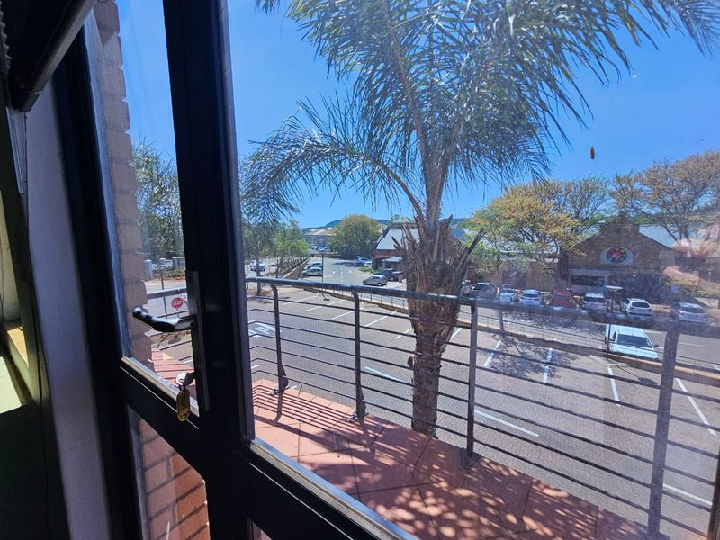 View from an elevated office space overlooking a parking area and surrounding commercial buildings.