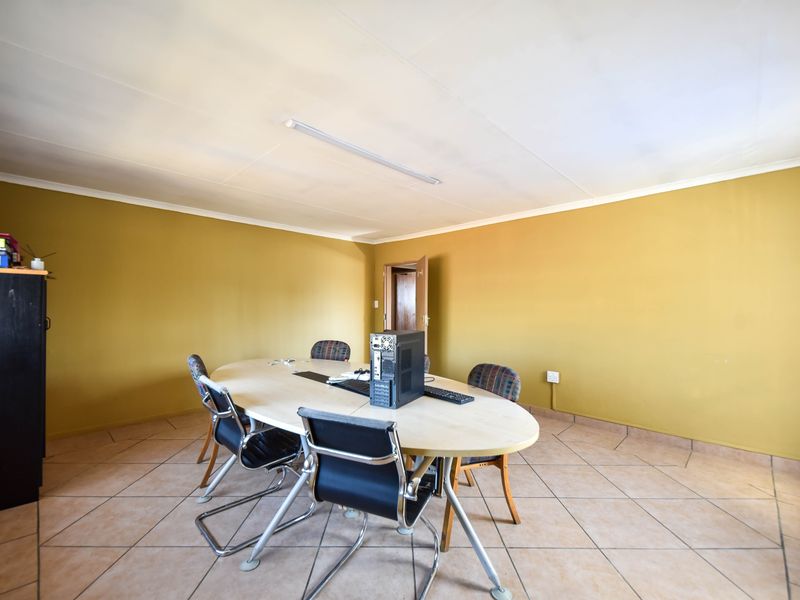A functional office space featuring tiled flooring and standard fluorescent lighting, suitable for a professional work environment.