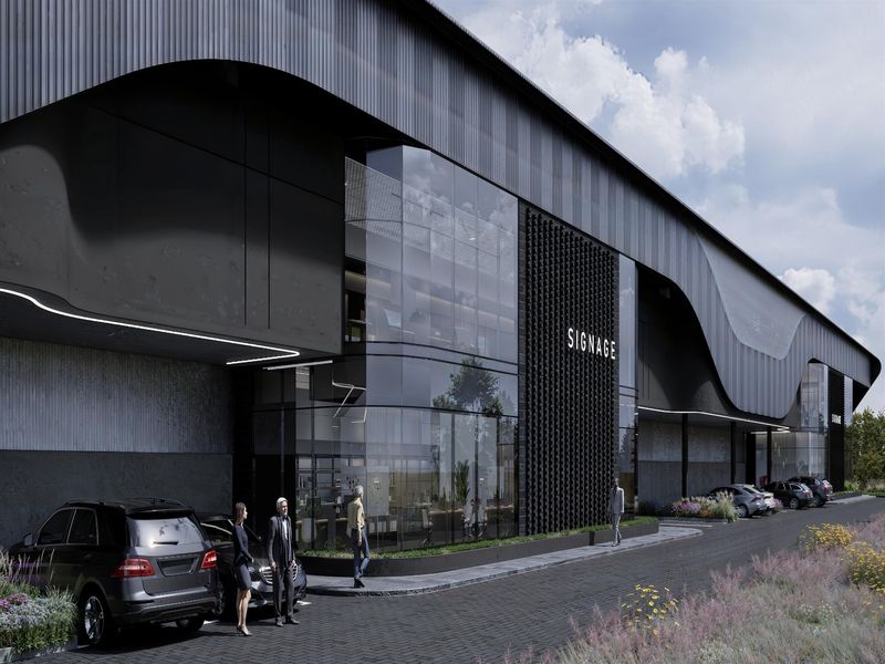 Modern industrial facility featuring a striking architectural facade with extensive glass curtain walling, metal cladding, and a professional paved entrance area.