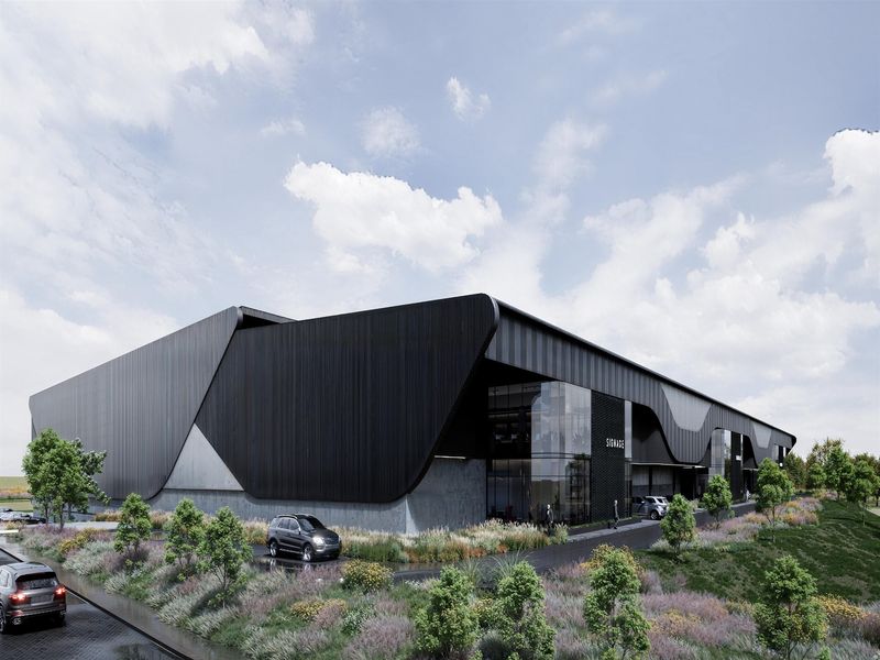 Modern industrial facility featuring sleek black metal cladding, expansive glass curtain walls, and professional landscaping.