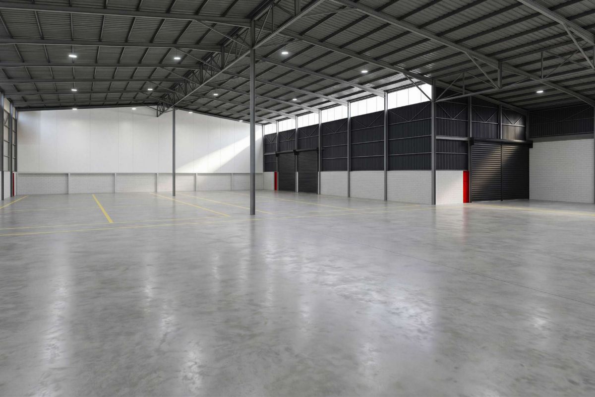 Spacious industrial warehouse featuring high ceilings, concrete flooring, roller shutter access, and modern LED lighting, suitable for various commercial or storage operations.