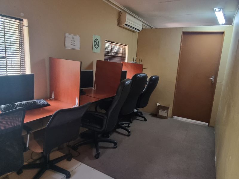 A functional office space featuring built-in desk partitions, air conditioning, and venetian blinds, suitable for a professional work environment.