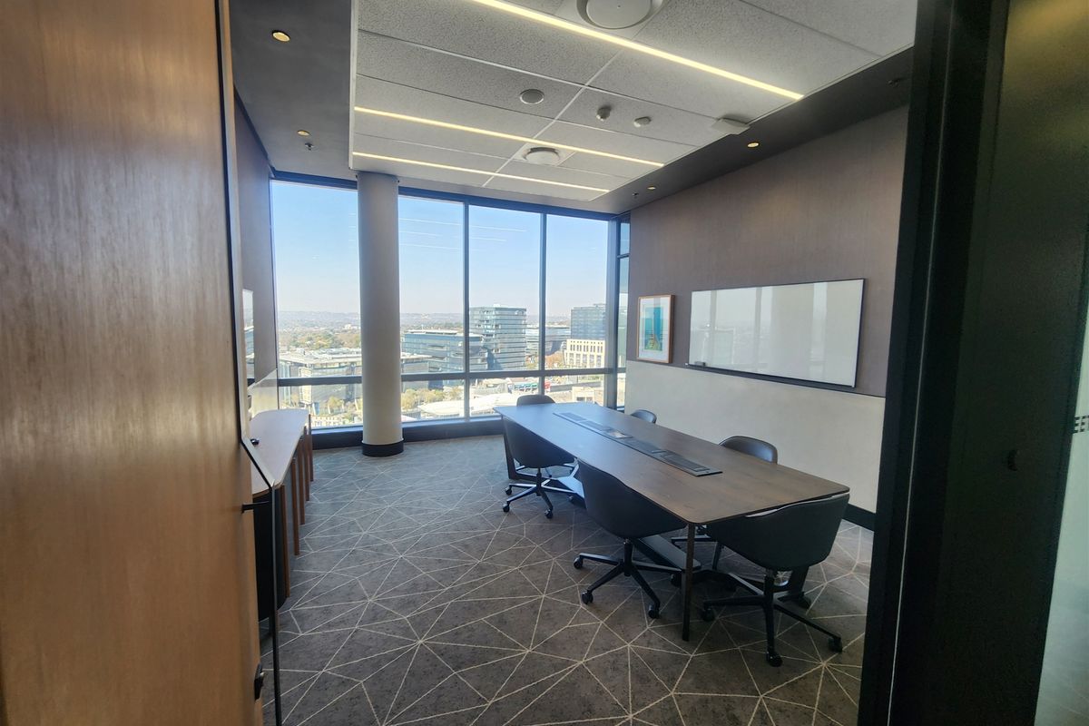 Modern professional office meeting room featuring floor-to-ceiling windows with city views, integrated ceiling lighting, and a wall-mounted whiteboard.