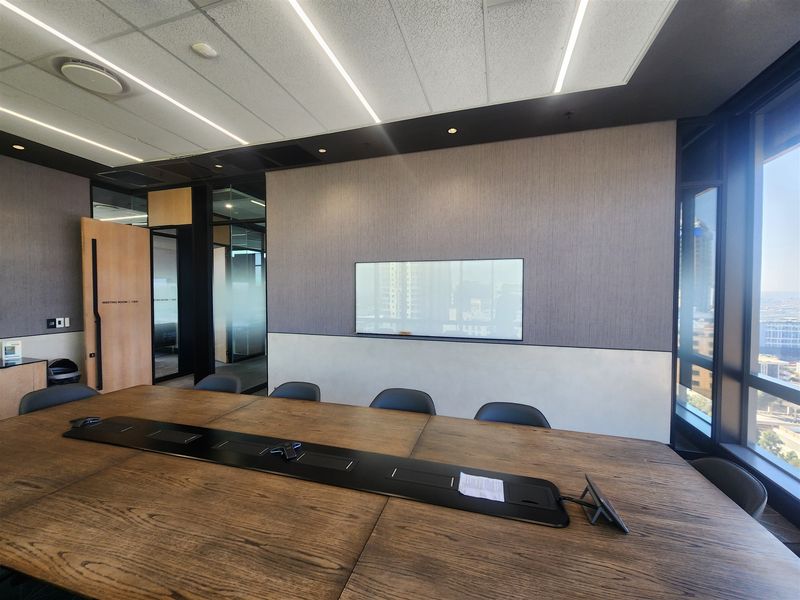 Modern professional boardroom featuring high-quality finishes, integrated data connectivity, acoustic ceiling panels, and expansive windows with natural light.