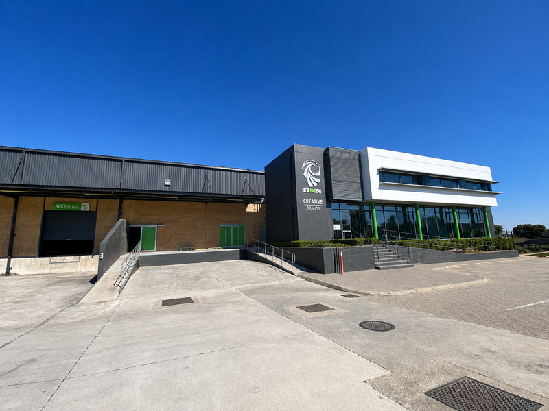 Modern industrial facility featuring a dedicated receiving loading bay, concrete yard, and a contemporary office facade with glass frontage.