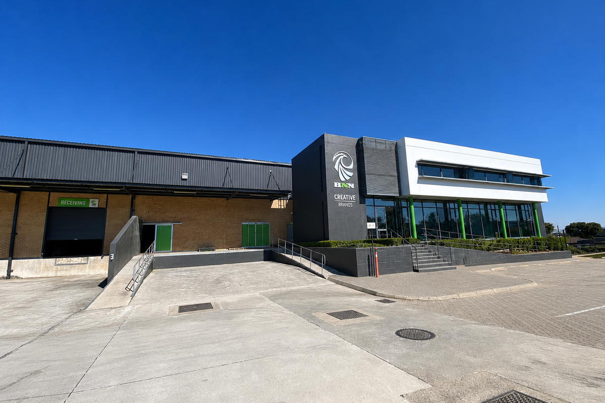 Modern industrial facility featuring a dedicated receiving loading bay, concrete yard, and a contemporary office facade with glass frontage.