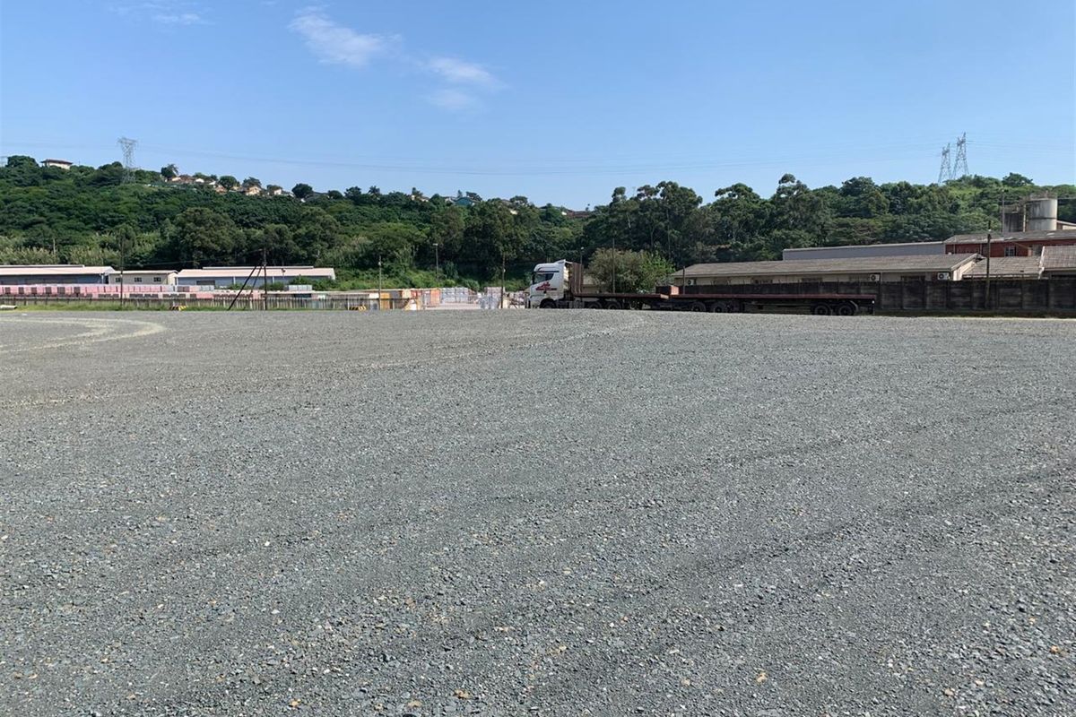 A wide-angle view of a large, level commercial vacant land plot featuring a gravel surface, suitable for industrial or logistics use.