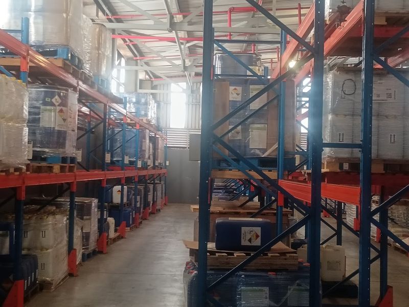 Industrial warehouse space featuring high-capacity steel racking systems, exposed roof trusses, and durable concrete flooring, suitable for storage and logistics operations.