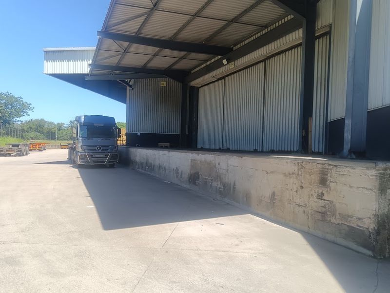 Industrial loading bay area featuring a concrete dock, steel roof canopy, and corrugated metal cladding, suitable for logistics and heavy vehicle access.