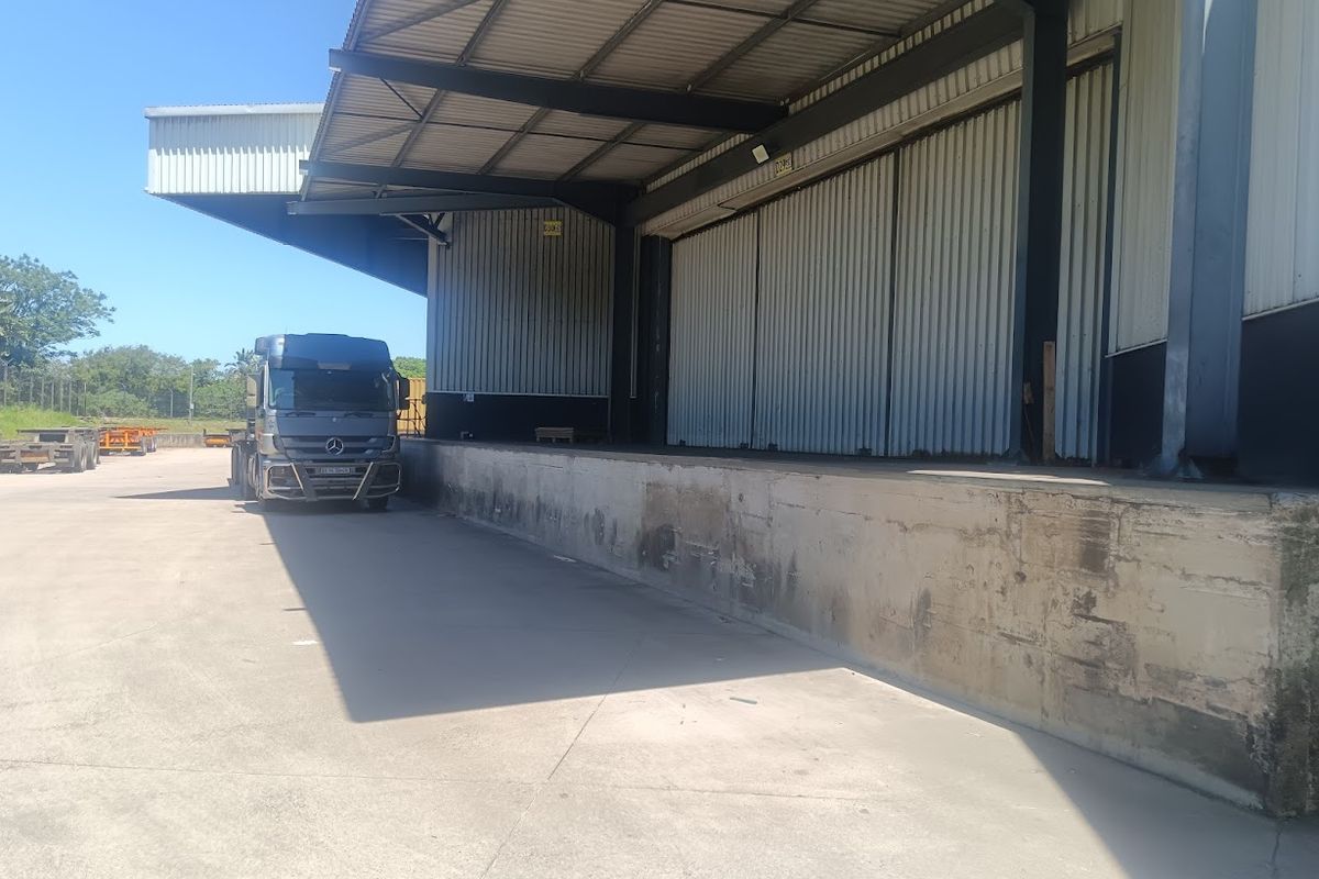 Industrial loading bay area featuring a concrete dock, steel roof canopy, and corrugated metal cladding, suitable for logistics and heavy vehicle access.