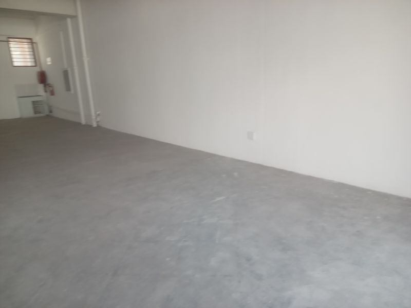An open-plan retail space featuring a neutral color palette, concrete flooring, and a clean, versatile layout suitable for various business configurations.
