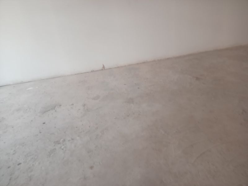 An empty, unfinished interior space featuring raw concrete flooring and plain wall surfaces, suitable for custom retail fit-out.