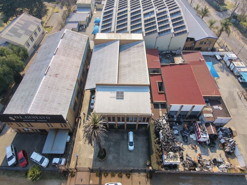 Aerial view of an industrial property complex featuring multiple warehouse buildings, metal roofing, and a paved yard area.