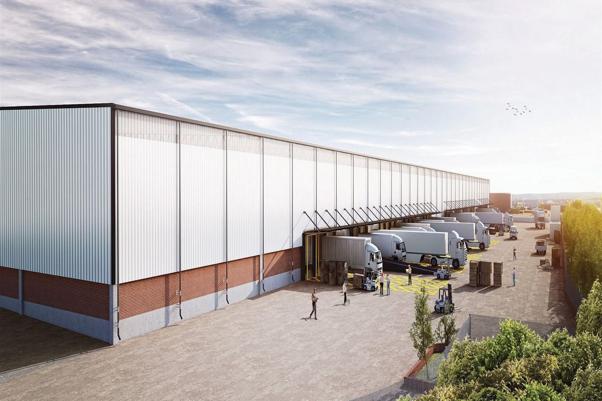 A wide-angle view of a large commercial warehouse facility featuring multiple loading docks, metal cladding, and a spacious concrete yard for logistics operations.