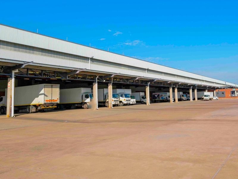 Industrial warehouse facility featuring a large concrete hardstand area and a covered loading bay canopy for efficient logistics and freight operations.