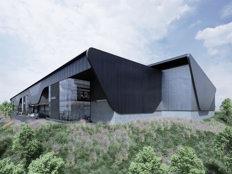 Modern industrial facility featuring sleek black metal cladding, expansive glass curtain walls, and a professional concrete foundation design.