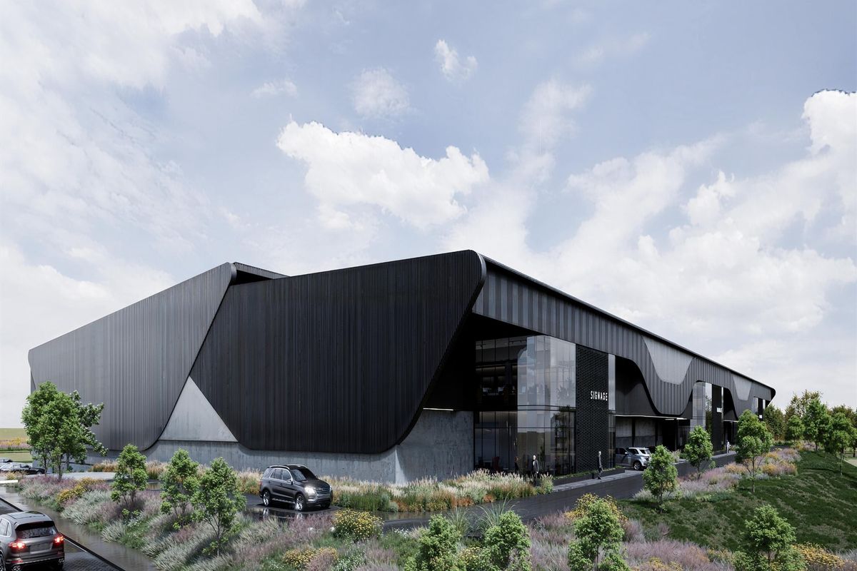 Modern industrial facility featuring sleek black metal cladding, expansive glass curtain walls, and professional landscaping.