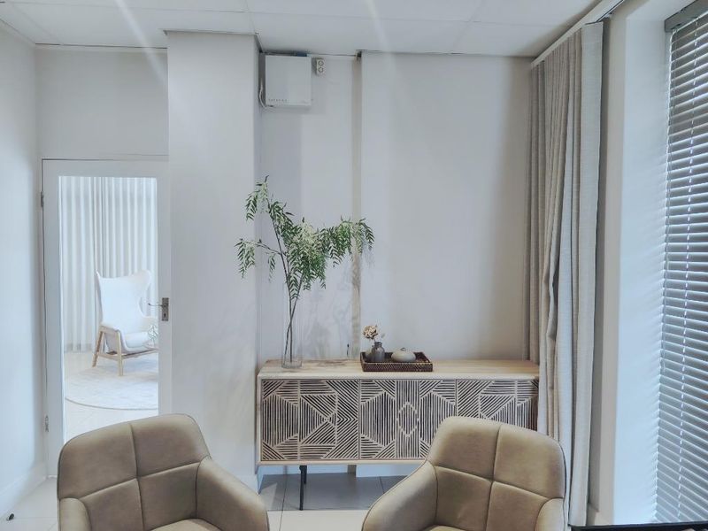 A bright office space featuring a neutral color palette, modern window treatments, and a clean, professional aesthetic suitable for a business environment.