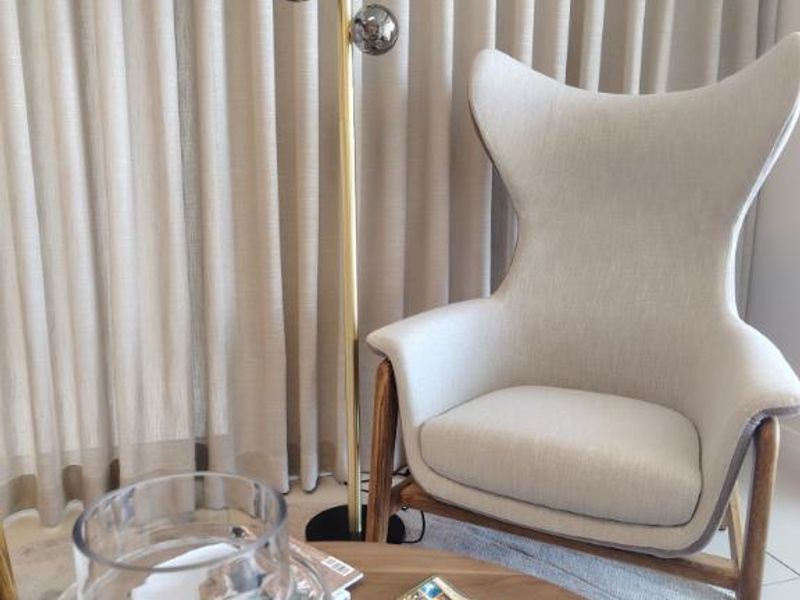 A comfortable seating area featuring floor-to-ceiling curtains, providing a soft and inviting atmosphere within the space.
