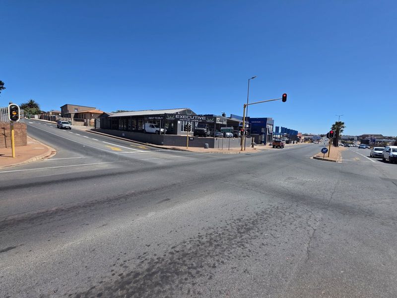 Street level view of a commercial property located at a busy intersection, featuring prominent road frontage and visibility.