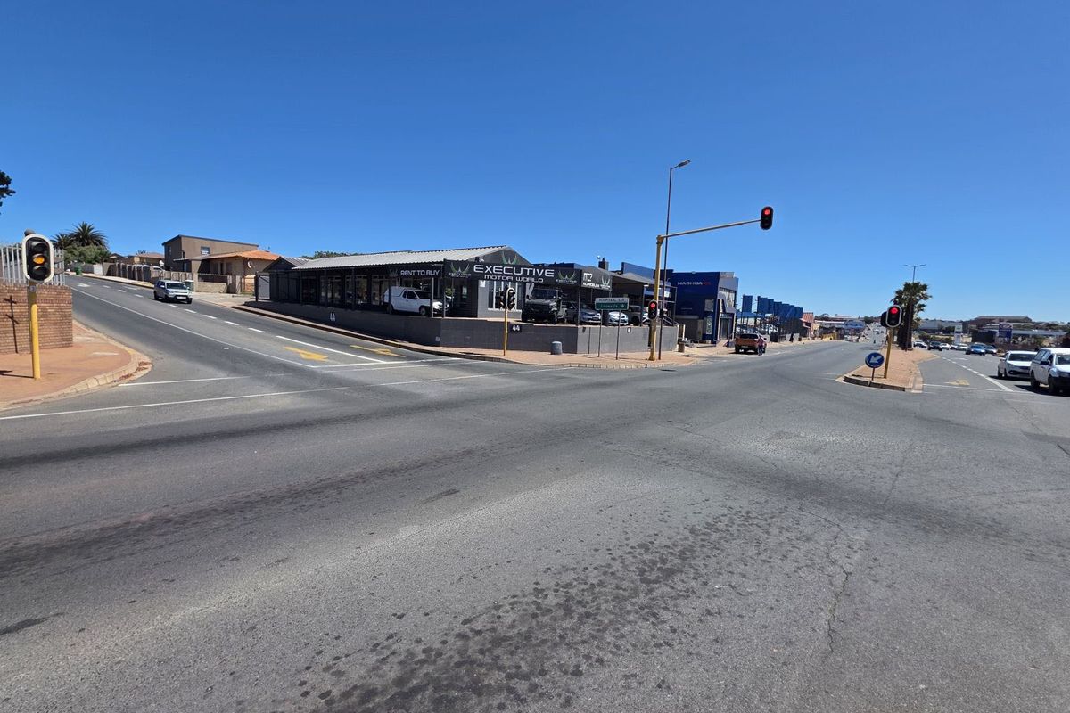Street level view of a commercial property located at a busy intersection, featuring prominent road frontage and visibility.