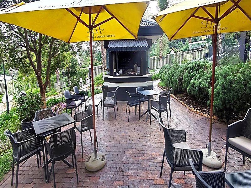 Outdoor patio area featuring brick paving and a fixed service kiosk, suitable for office break times or casual meetings.