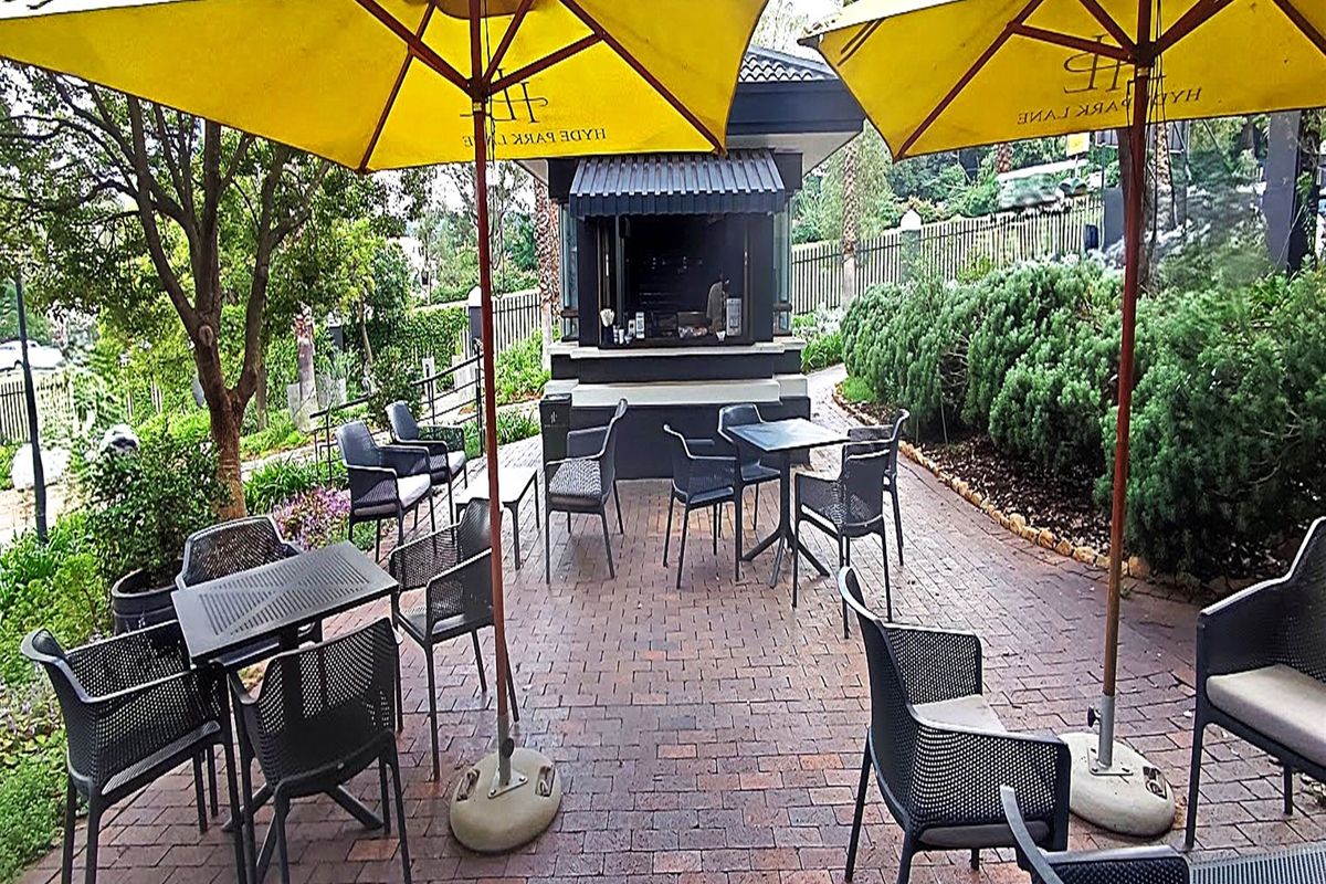Outdoor patio area featuring brick paving and a fixed service kiosk, suitable for office break times or casual meetings.