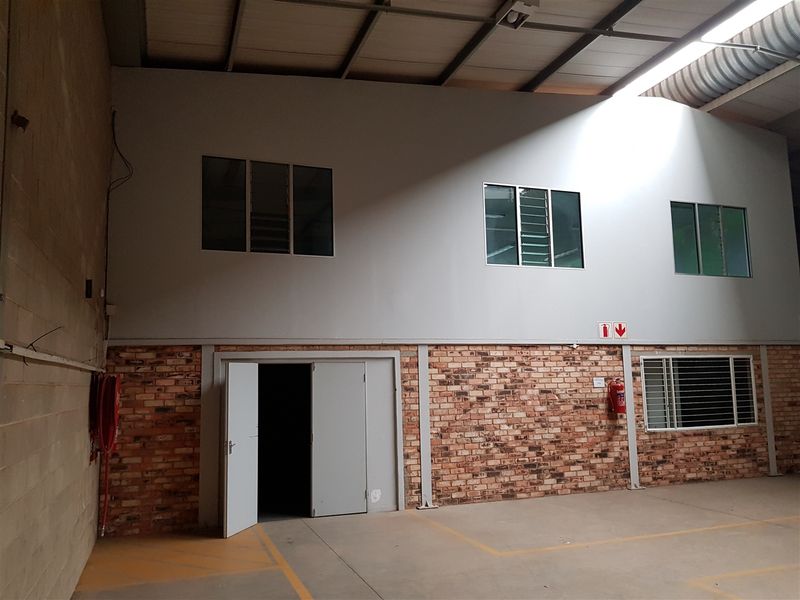 Spacious industrial utility area featuring exposed brick walls, steel structural supports, concrete flooring, and integrated fire safety equipment.