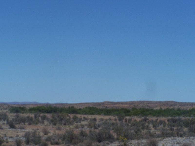 A wide-angle view of the expansive rural landscape and natural vegetation surrounding the property.