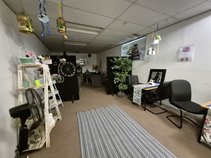An office space currently utilized as a beauty salon, featuring a suspended ceiling and carpeted flooring, suitable for various commercial or professional office uses.