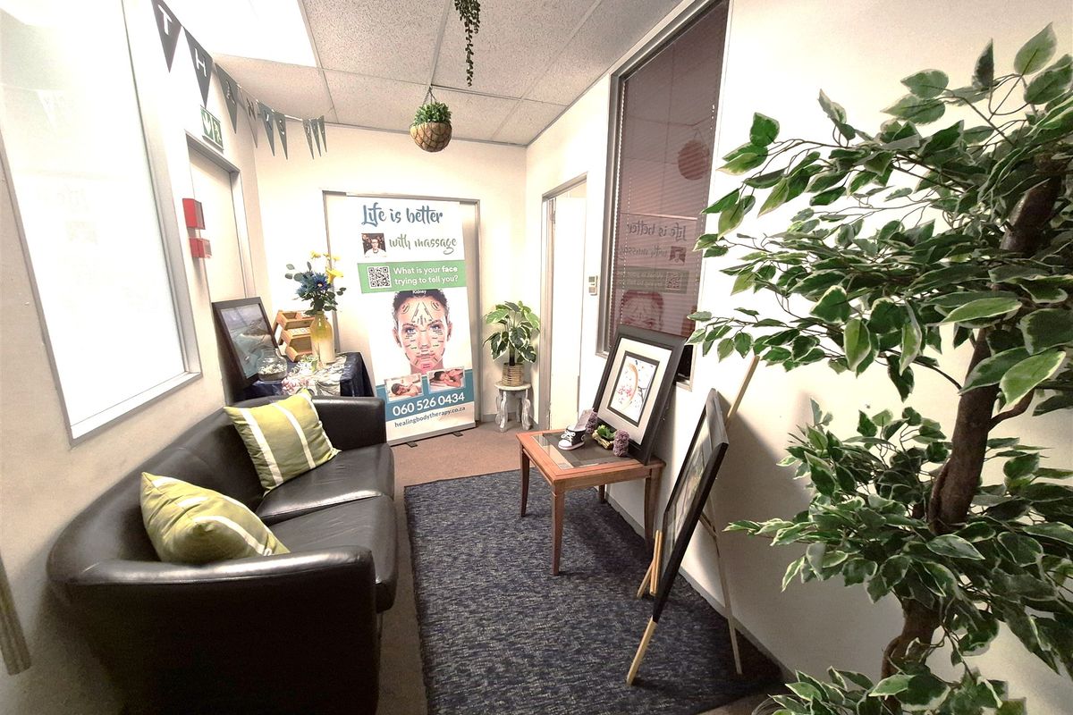 A compact office space featuring a suspended ceiling, carpeted flooring, and an internal glass partition, suitable for a professional workspace or consultation room.