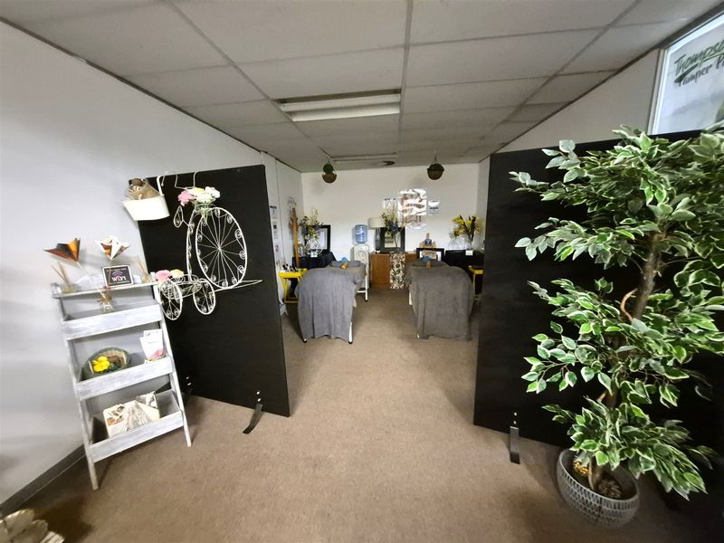 An office space featuring a suspended ceiling and carpeted flooring, currently partitioned into treatment areas.