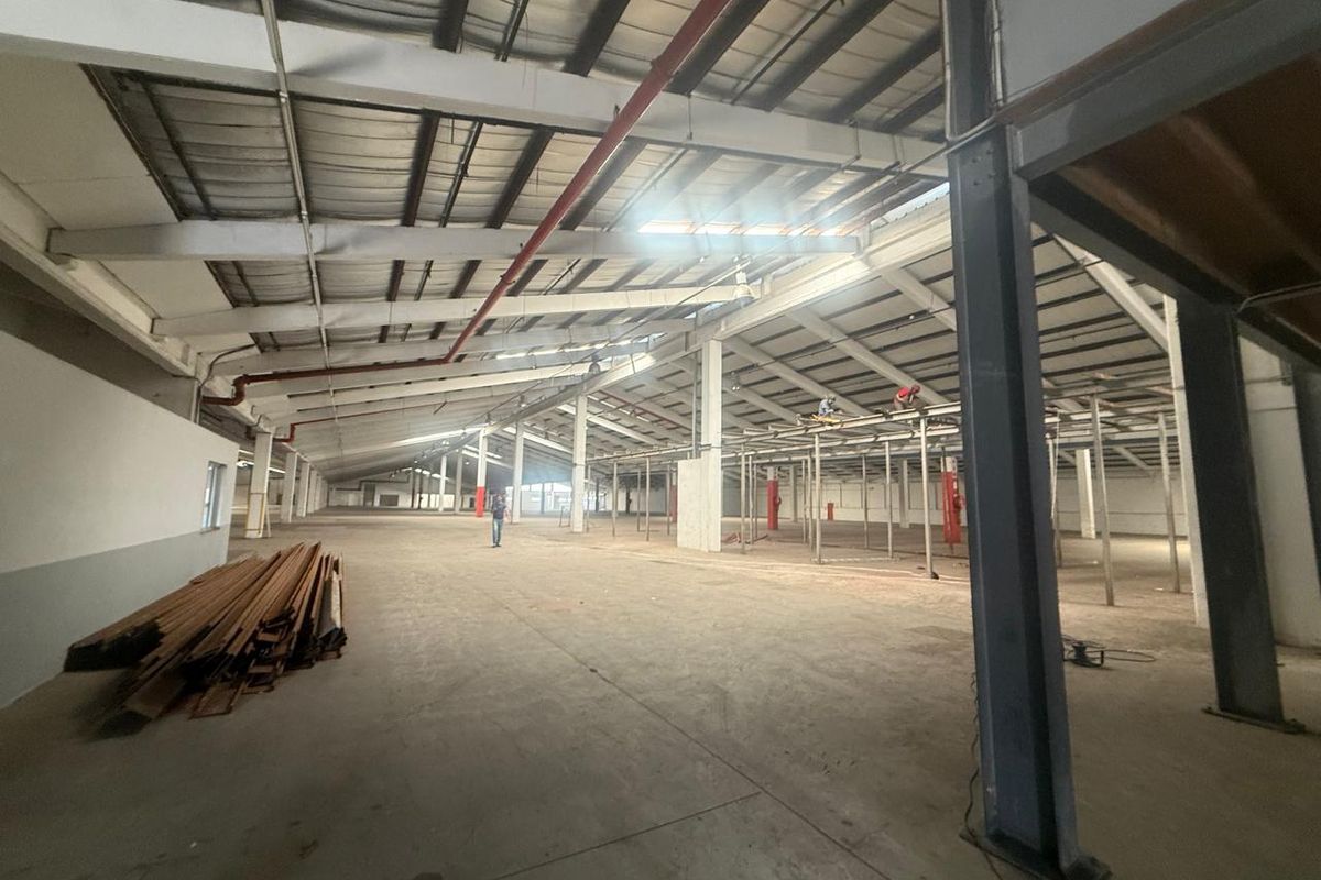 Expansive industrial warehouse space featuring high ceilings, exposed steel structural beams, concrete flooring, and open-plan layout suitable for manufacturing or storage operations.