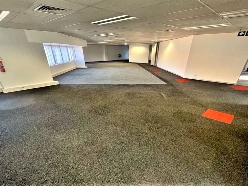 Spacious, open-plan office area featuring suspended ceilings, recessed lighting, air conditioning, and carpeted flooring throughout.