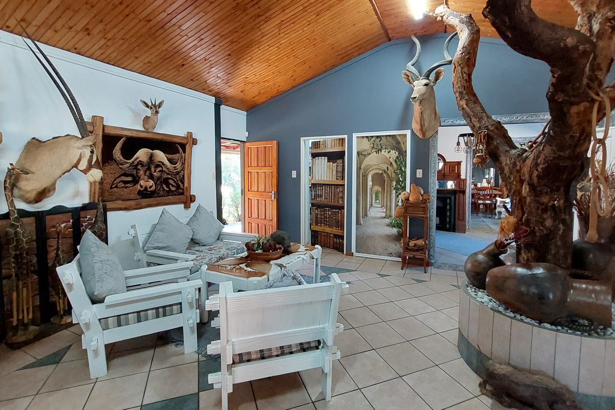Spacious living area featuring a vaulted timber-clad ceiling, ceramic tiled flooring, and a unique built-in decorative tree feature.