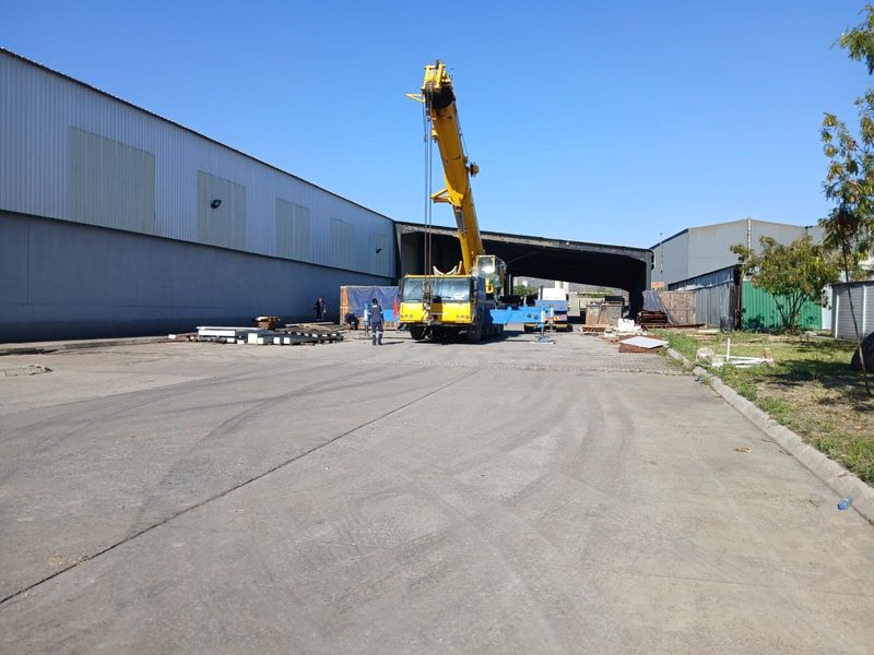 Spacious industrial yard featuring concrete hardstand, large warehouse structure, and open loading area suitable for heavy machinery and logistics operations.